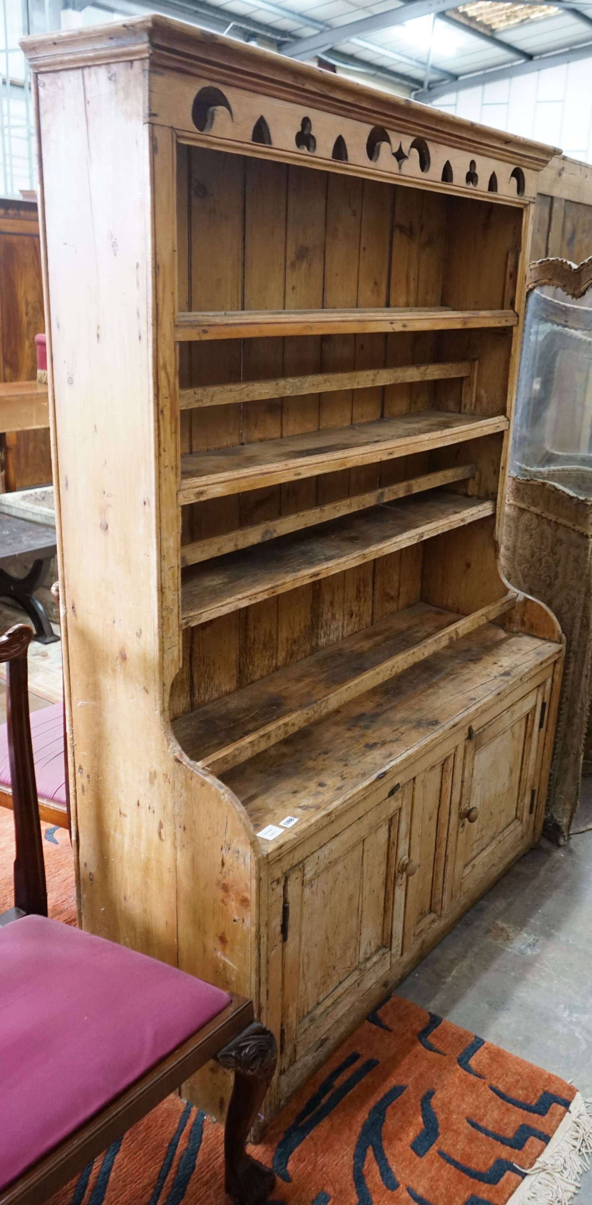 An early 19th century Irish pine dresser with boarded rack, length 129cm, depth 49cm, height 185cm